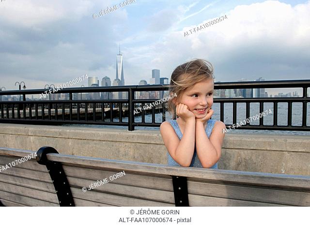 Little girl resting on pier near New York City, New York, USA