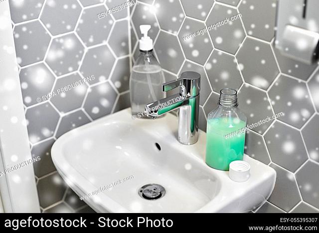 close up of water tap with liquid soap on sink