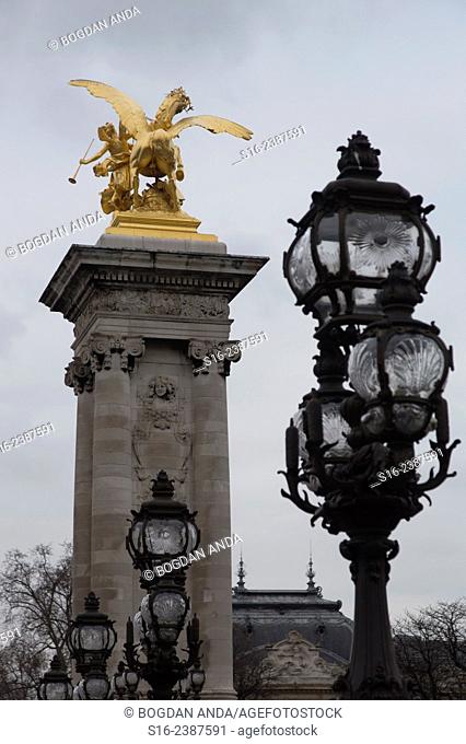 Paris, France - Street lamps and golden statue on Alexandre III bridge over river Seine