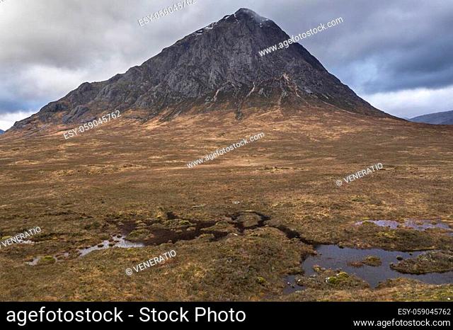Flying drone dramatic landscape image of Buachaille Etive Mor and surrounding mountains and valleys in Scottish Highlands on a Winter day