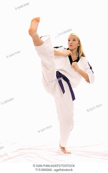 young woman practice a karate high kick