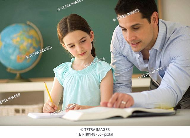Teacher helping schoolgirl 8-9