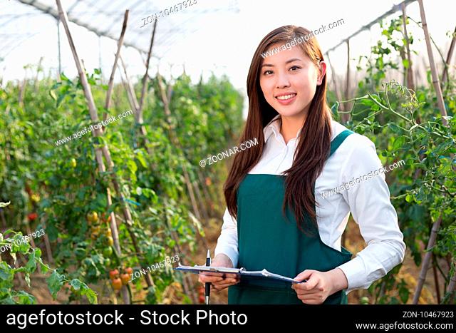 young beautiful asian woman works in green field