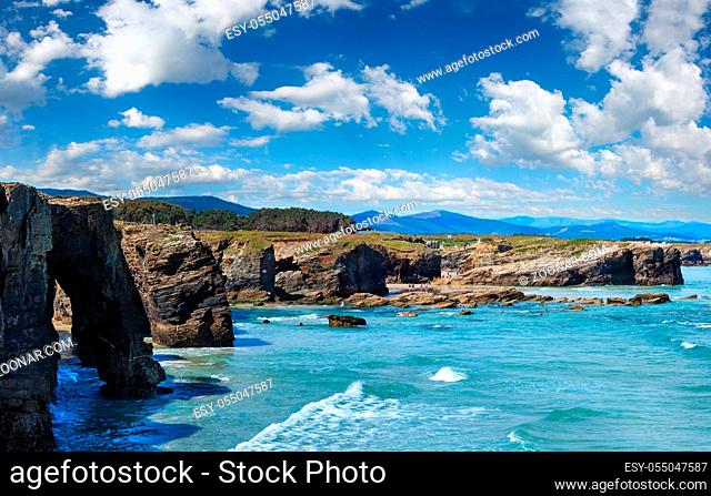 Natural rock arches on As Catedrais beach in low tide (Cantabric coast, Lugo, Galicia, Spain). Peoples are unrecognizable