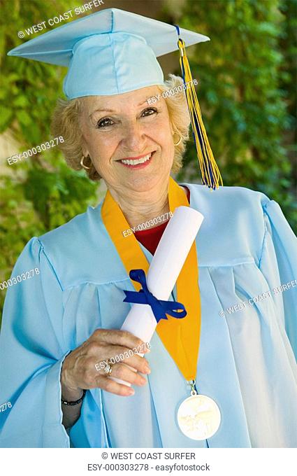 Senior graduate holding diploma outside portrait