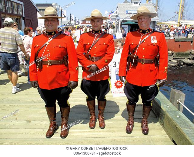 Three Royal Canadian Mounted Police officers in red ceremonial dress uniform