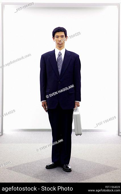 Portrait serious businessman in suit with briefcase