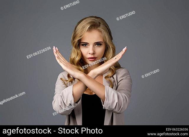 beautiful business woman making stop gesture on gray background
