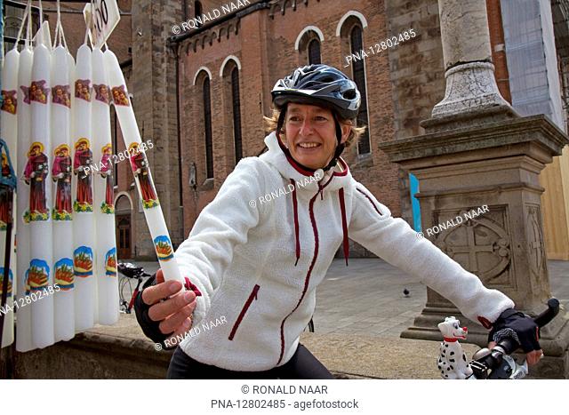 PADOVA - Cyclist, a woman looks at Sant Antonio candles, Padova, Veneto, Italy ANP COPYRIGHT RONALD NAAR