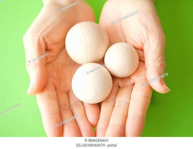 Close up of hands holding wooden balls