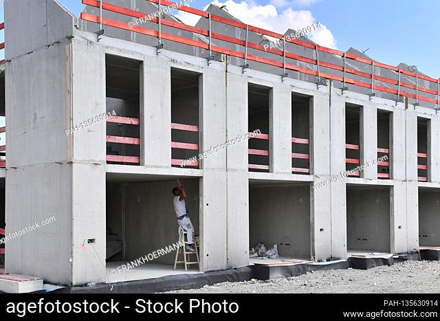 Construction workers on a large construction site, workers grouting concrete walls, prefabricated walls. New apartments, shell construction, terraced houses