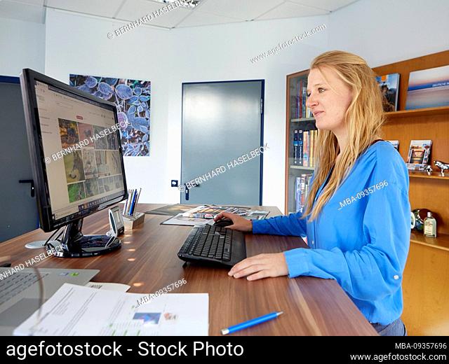 young woman works on the computer at a standing desk