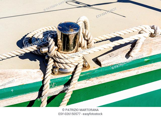 Fragmentary view details of knots and ropes on the yacht moored in the dock. .Oarlock and rope on a sailboat