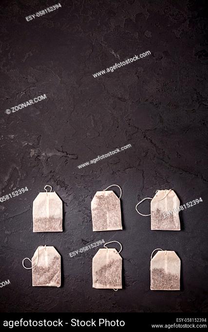 Assorted tea bags on black stone background