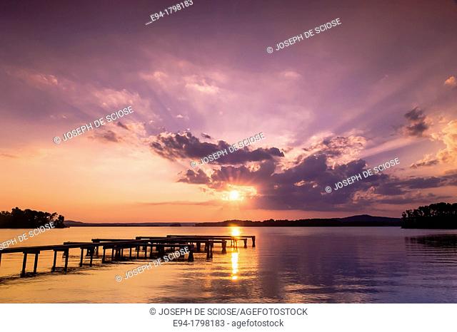Sunset over a lake with a small boat dock silhouetted in the foreground, Lake Guntersville State Park, Alabama, USA
