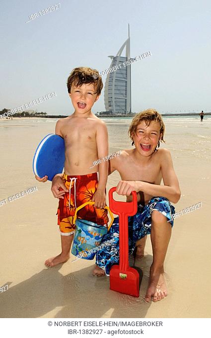 Children playing on the beach in front of the Burj al Arab Hotel, Dubai, United Arab Emirates, Middle East