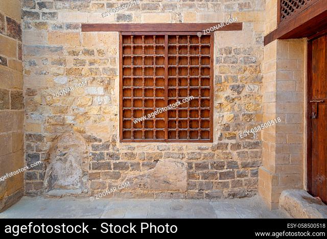 Mamluk era wooden closed window with wooden ornate grid over stone bricks wall, Tekkeyet Al Bustami, Dar El Labbana district, Cairo, Egypt