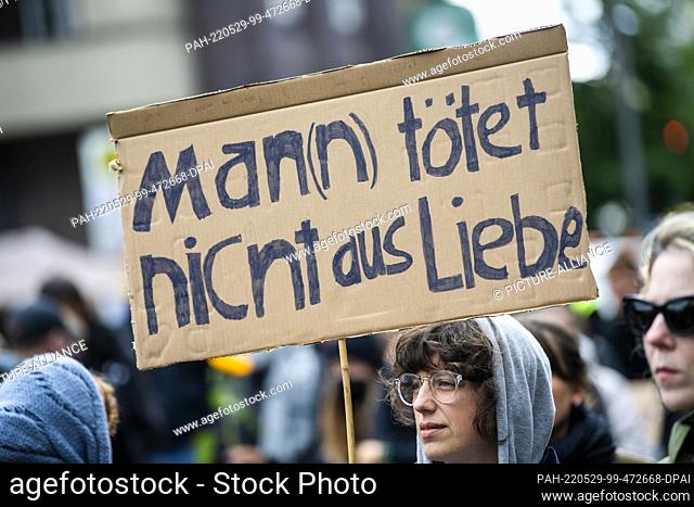 29 May 2022, Berlin: During a demonstration against violence against women, a participant holds a placard with the inscription ""Man(n) does not kill for love""