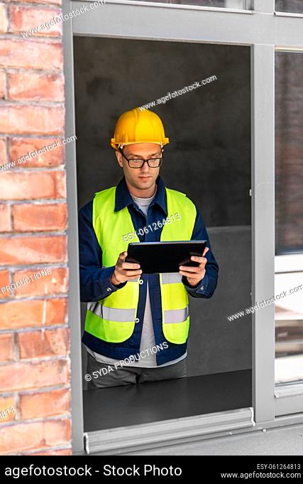 architect in helmet and safety west with tablet pc