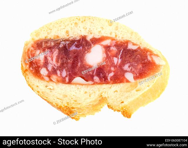 top view of open sandwich with fresh bread and slice of cured sausage isolated on white background