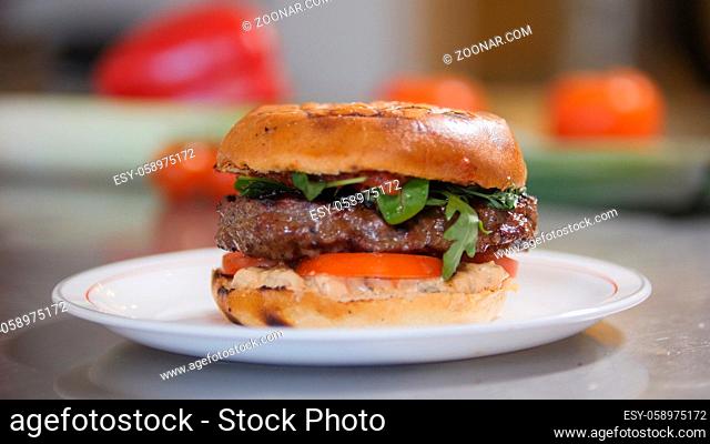 Burger with potato chips on a plate in restaurant kitchen, cooking and Haute cuisine concept