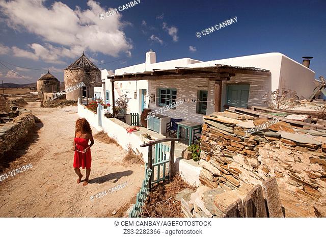 Woman in front of a Cyclades house and old windmills, Folegandros, Cyclades Islands, Greek Islands, Greece, Europe