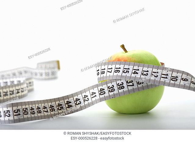 Apple with a measuring tape on white