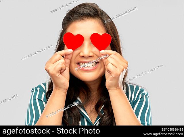 happy asian woman covering her eyes with red heart