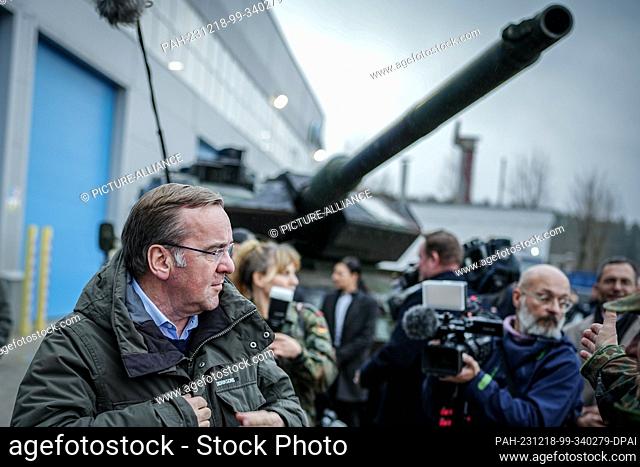 18 December 2023, Lithuania, Jonava: Boris Pistorius (SPD), Federal Minister of Defense, stands in front of a Leopard 2 tank from Ukraine at the Lithuanian...
