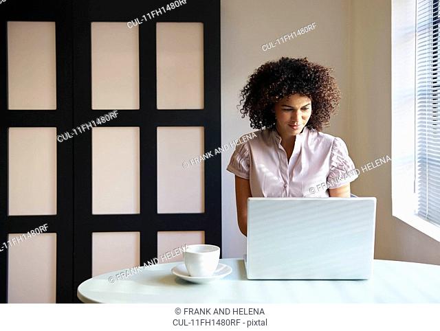 Woman in cafe working on laptop