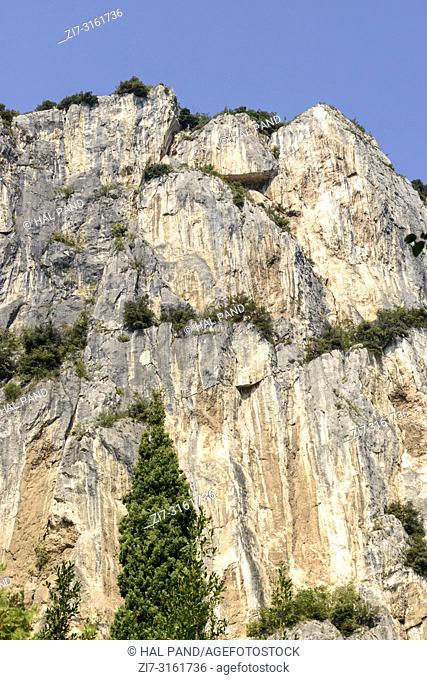 landscape with overhanging cliffs , shot in bright fall light near Arco, Trento, Italy