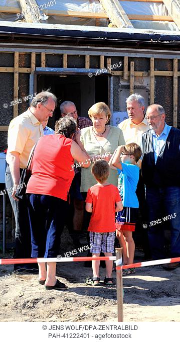 German Chancellor Angela Merkel (CDU, C) and Premier of Saxony-Anhalt Reiner Haselhoff (CDU, L) visit residents affected by the flood earlier this year in...