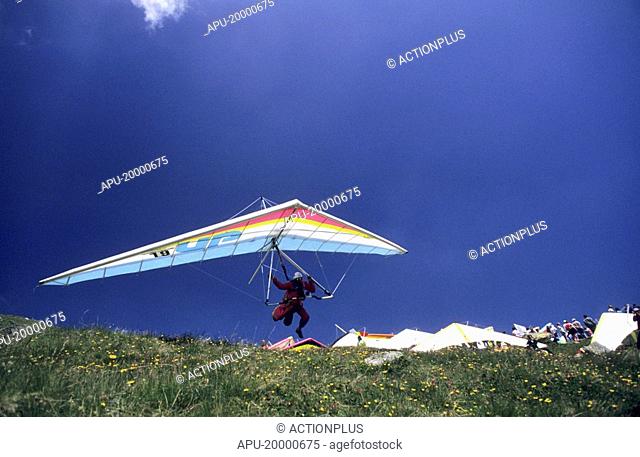 Hang glider taking off from a busy hill side