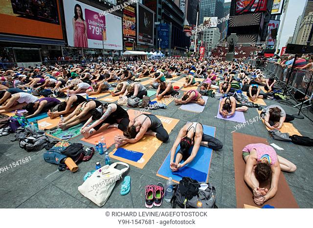 Thousands of yoga practitioners in Times Square in New York participate in a group Bikram Yoga class observing the Summer Solstice The classes given throughout...