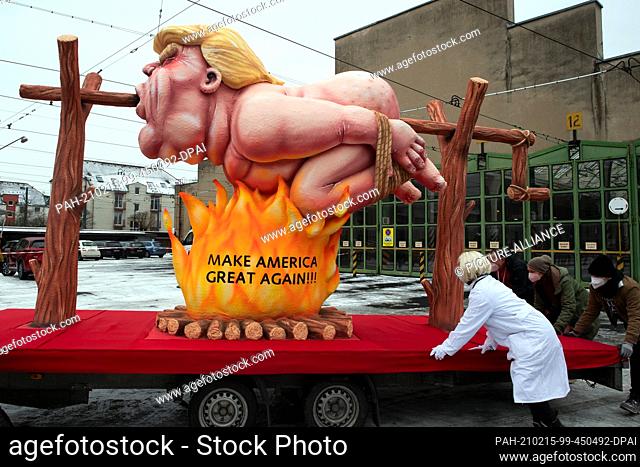 15 February 2021, North Rhine-Westphalia, Duesseldorf: A motto float with a figure meant to represent US President-elect Donald Trump grilling over a fire is...