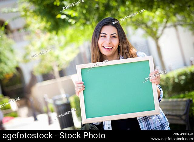 Portrait of An Attractive Excited Mixed Race Female Student Holding Blank Chalkboard and Carrying Backpack on School Campus
