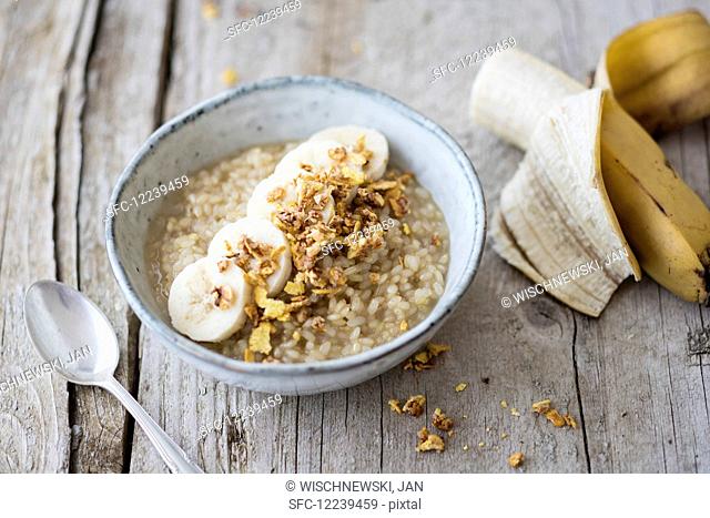 Rice porridge made with lupin and coconut milk with banana and crunchy flakes