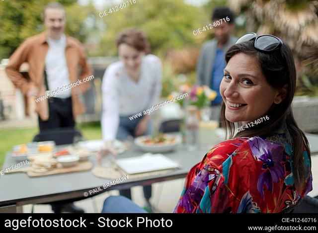 Portrait happy woman enjoying lunch with friends at patio table