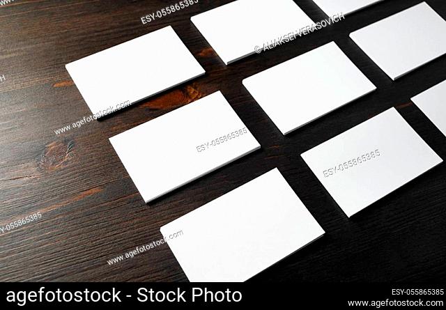 Many blank business cards on wood table background. Blank paperwork template for placing your design. Mockup for ID