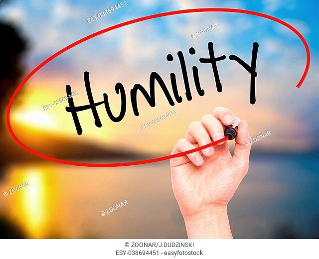 Man Hand writing Humility with black marker on visual screen