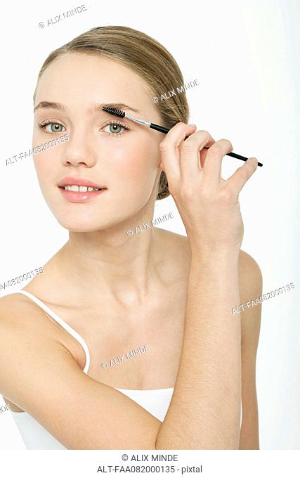Preteen girl using eyebrow brush