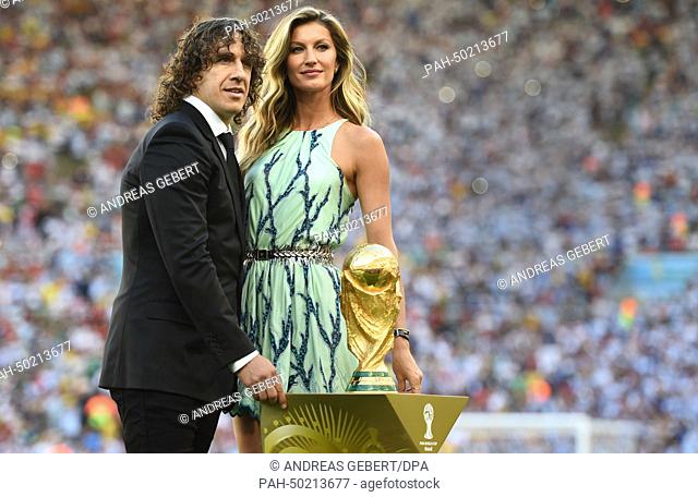Former soccer Carles Puyol of Spain and Brazilian fashion model Gisele Buendchen pose with World Cup trophy prior to the FIFA World Cup 2014 final soccer match...