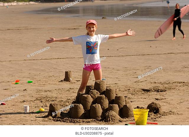 Young girl playing in sand on beach