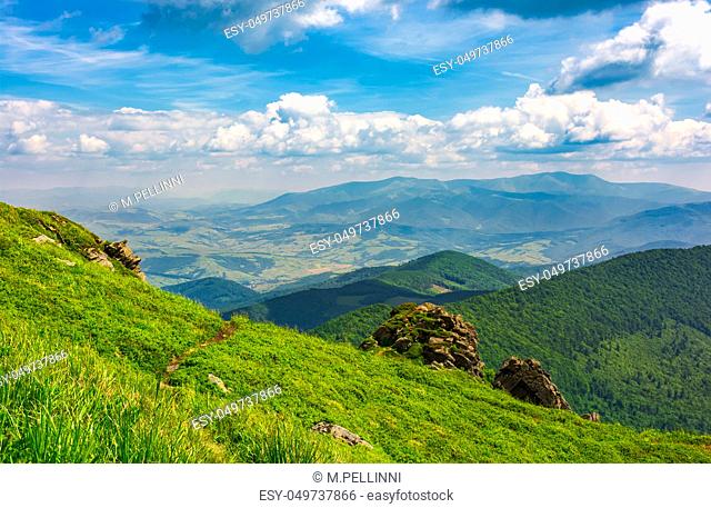 beautiful mountain landscape with grassy hills. blue sky with fluffy clouds. foot path uphill