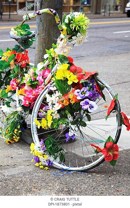 oregon, united states of america, a bike decorated with flowers leaning against a pole