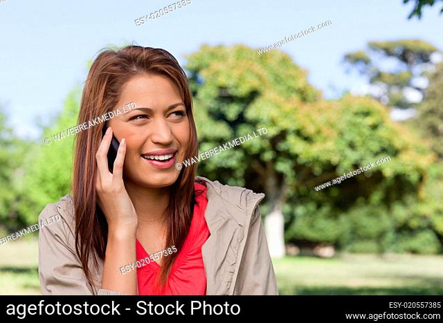 Woman smiling while looking towards her left side in an open grassland area