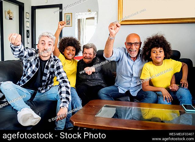 Cheerful multi-ethnic family celebrating victory at home