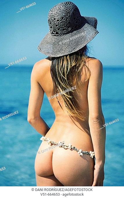 Young naked woman looking to the sea