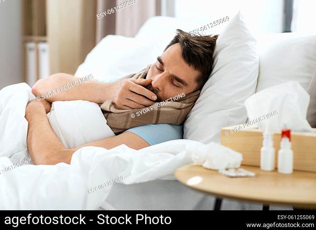 sick man coughing in bed at home