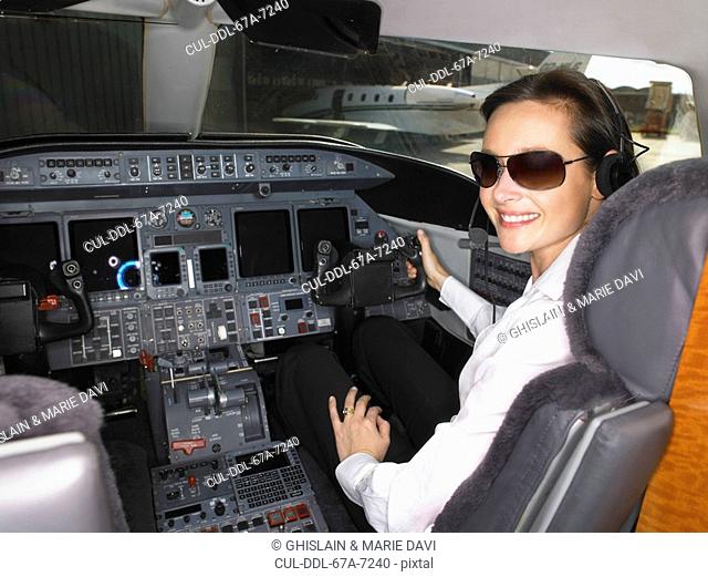 Female pilot in cockpit of private jet